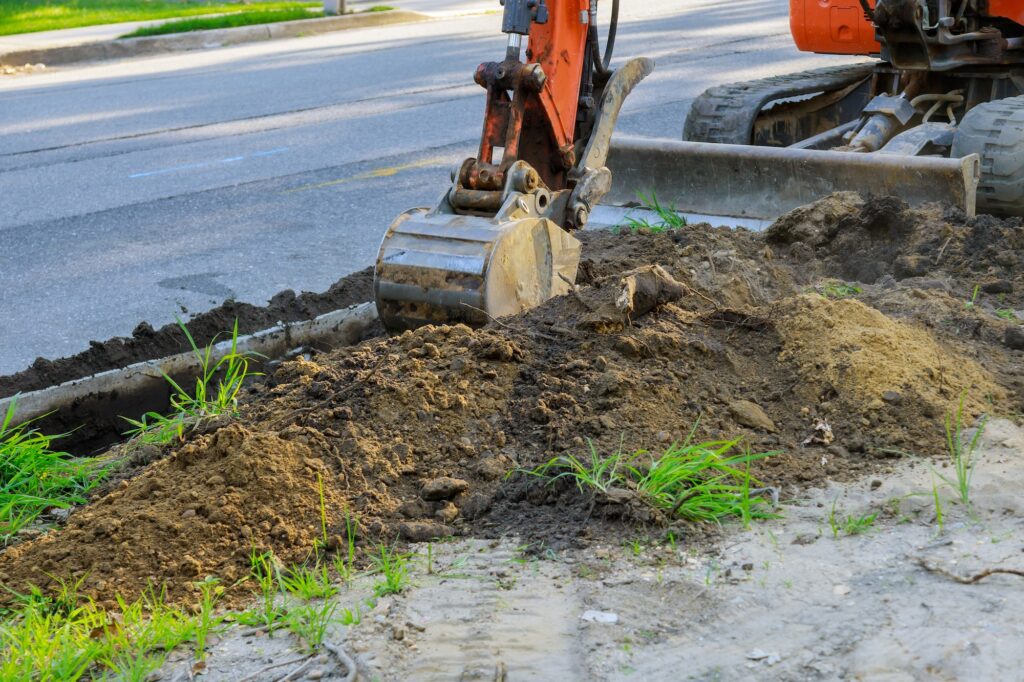 Digger working at construction in excavation pit