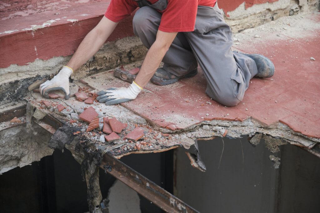 Unrecognizable man pulling the roof of a house down.